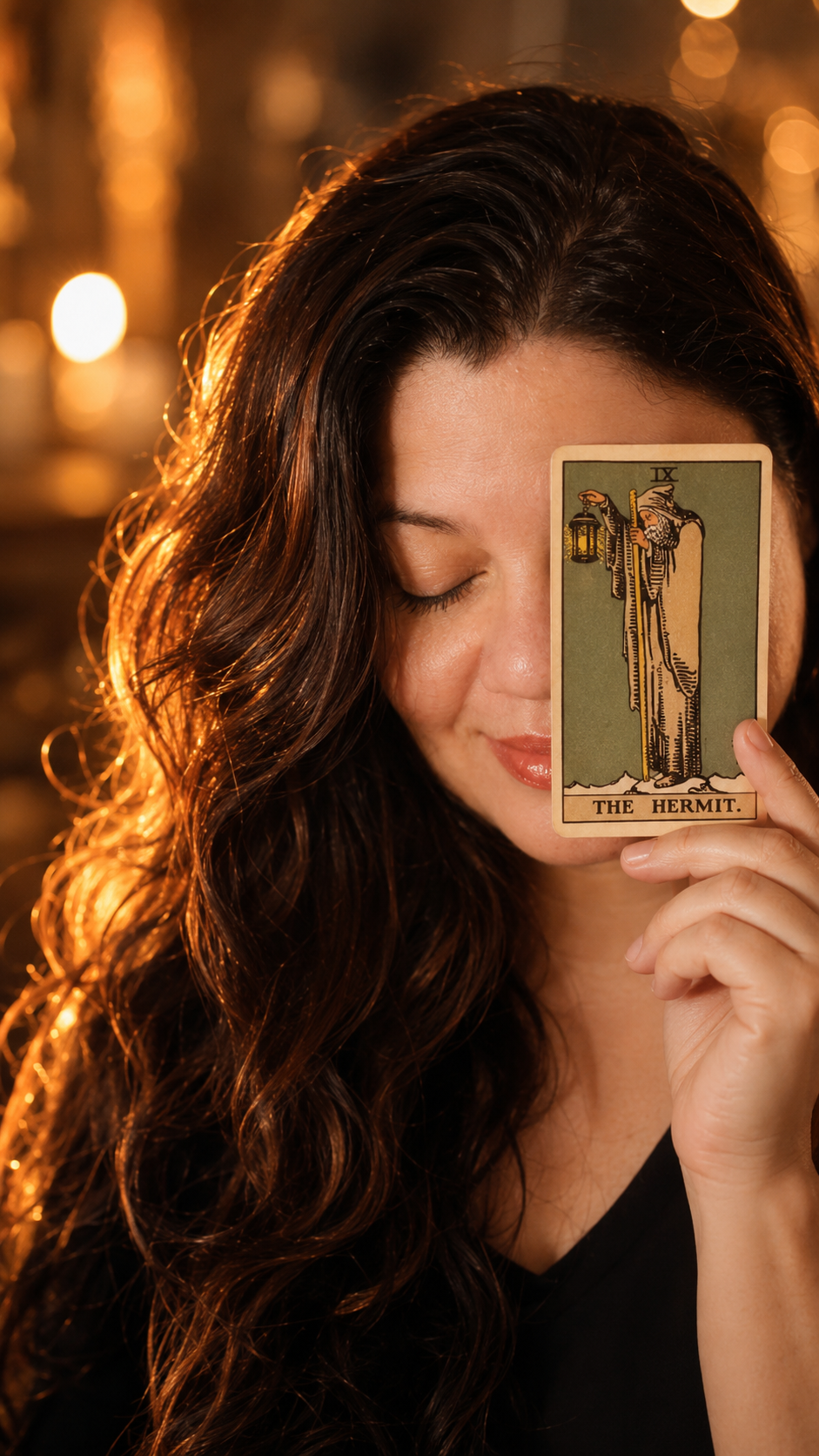 Viviane Oliveira segurando uma carta de tarot à luz de velas